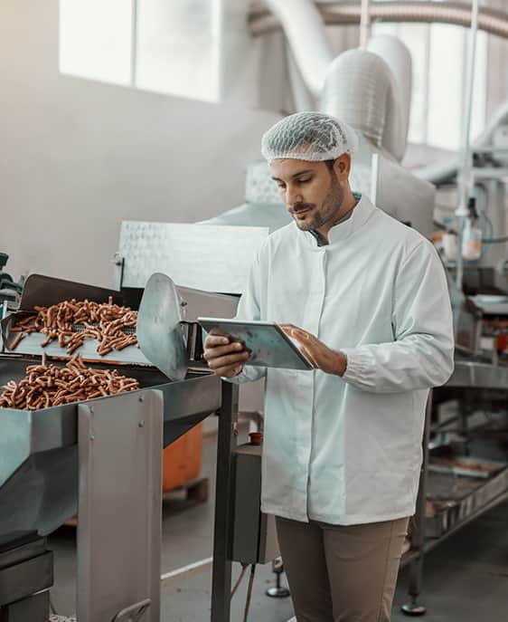 A man wearing a white coat is interacting with a tablet.