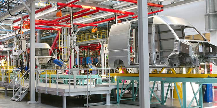 An assembly line in a factory featuring numerous vehicles, highlighting the manufacturing process in action.