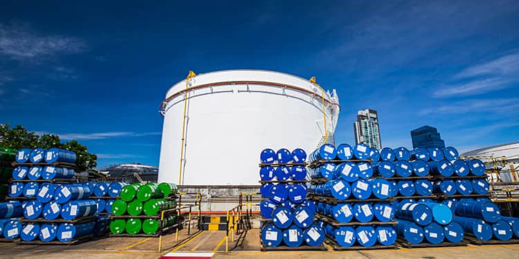 A prominent white tank with multiple blue barrels stacked on its top.