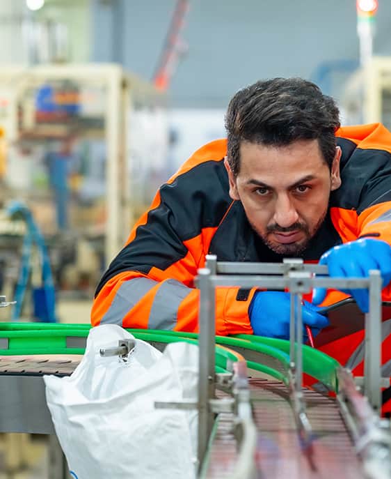 Maintenance technician reviews training materials on consumer goods production floor