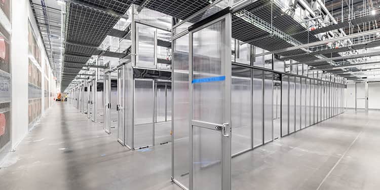 A spacious room featuring numerous glass doors and a wide hallway.