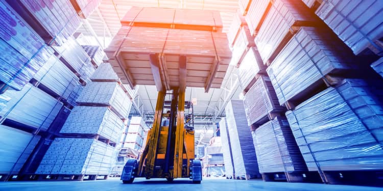 A forklift navigates through a busy warehouse, transporting goods between shelves.